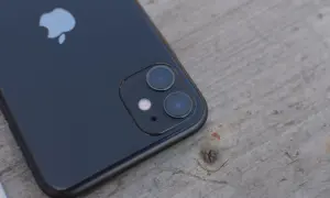 Czarne iPhone'a z podwójnym aparatem na drewnianym tle. Dowiedz się, jak wyłączyć Live Photo.