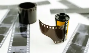 Zastanawiasz się, ile kosztuje wywołanie kliszy Kodak? Na zdjęciu widać rolki i paski negatywów filmowych, gotowe do obróbki.