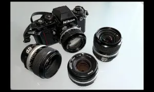 Stary aparat fotograficzny na klisze Nikon F3 z kilkoma obiektywami Nikkor.