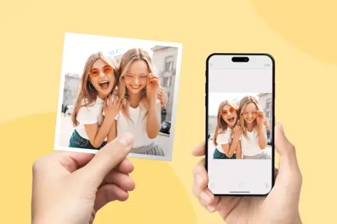 Dwie uśmiechnięte dziewczyny w okularach przeciwsłonecznych na zdjęciu i na ekranie telefonu. Dowiedz się, jak wywołać zdjęcie z telefonu.