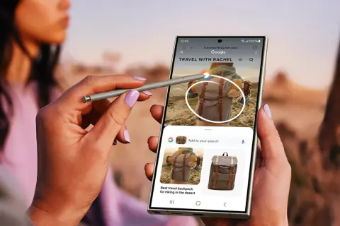 Ręka z rysikiem S Pen używa aparatu cyfrowego Samsung Galaxy do wyszukiwania plecaków podróżnych.