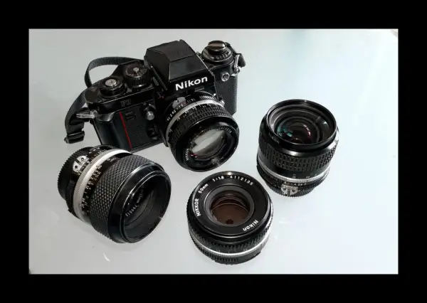 Stary aparat fotograficzny na klisze Nikon F3 z kilkoma obiektywami Nikkor.
